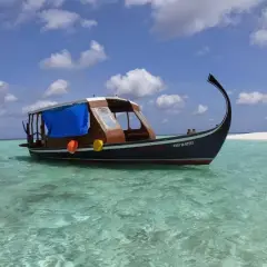 Tradycyjna łódź dhoni kołysze się na turkusowych wodach niedaleko stolicy Malediwów.