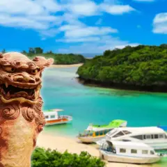 Kamienna lwica strzeże rajskiej plaży z łodziami na turkusowej wodzie. To piękny archipelag z Okinawą w tle.