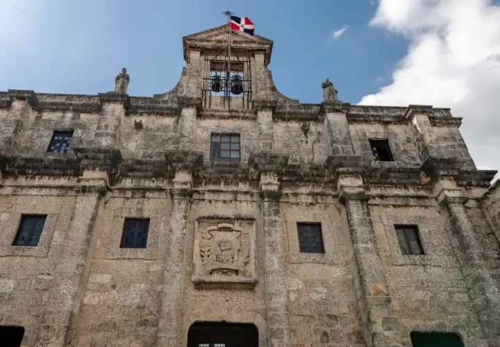 Kamienne mury Alcázaru de Colón, symbolu stolicy Dominikany, Santo Domingo. Flaga powiewa nad dzwonami.