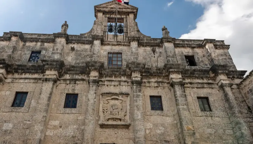 Kamienne mury Alcázaru de Colón, symbolu stolicy Dominikany, Santo Domingo. Flaga powiewa nad dzwonami.