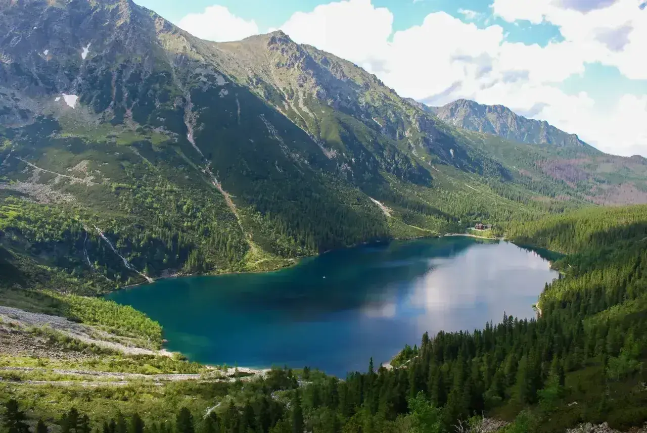 Malownicze Morskie Oko, idealne na górską trasę. Jezioro otoczone zielonymi lasami i skalistymi szczytami Tatr.