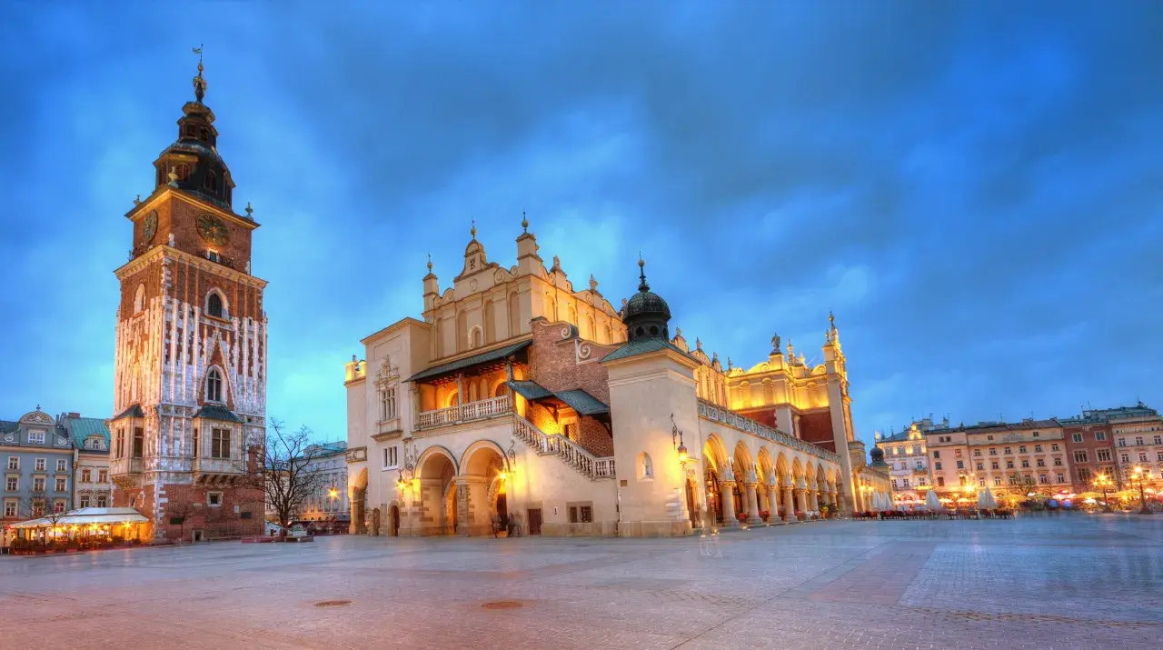 Wieczorny widok na Rynek Główny w Krakowie z Sukiennicami i wieżą Ratuszową.